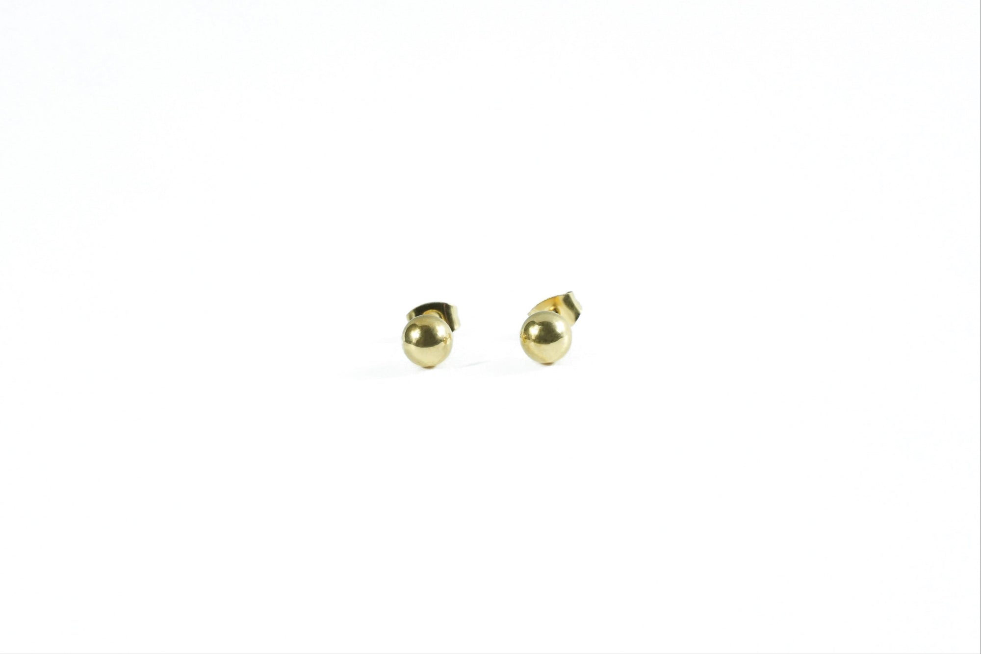 earring with a minimalist gold ball, perfect for both casual and formal looks.
