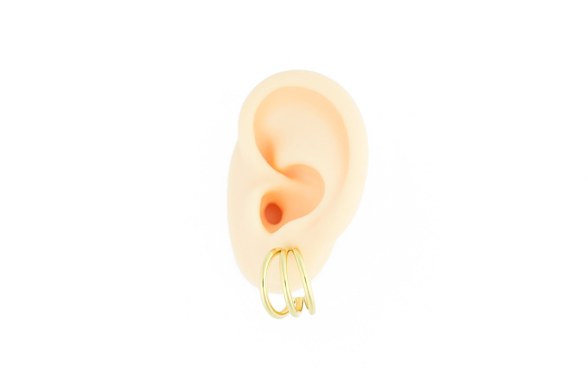 Trendy gold colored earrings by designonearth
in ear on a white background
